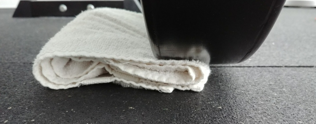 Folded up towel under bumper plate