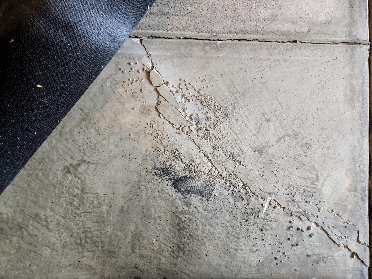 Cracked concrete under gym mats from bumper plates