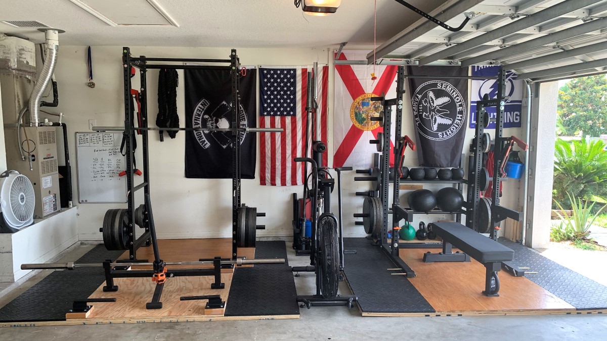 garage gym with two squat racks and weight benches