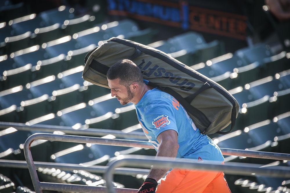 An athlete carrying the Rogue sandbag